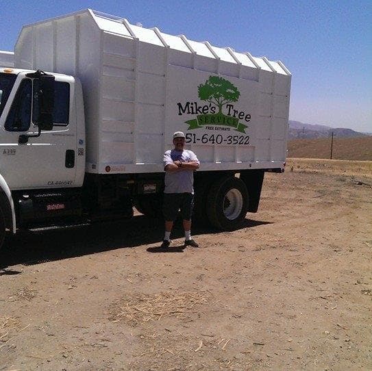 Mike Dick standing in front of Mike's Tree Service truck
